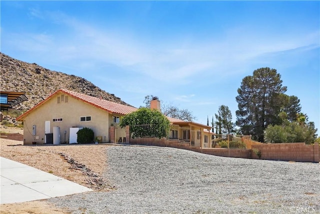 15710 Rimrock Rd, Apple Valley, CA 92307 - view of front facade with stucco siding, a chimney, fence, and a tile roof