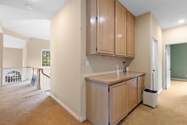 corridor featuring an upstairs landing, baseboards, and light carpet