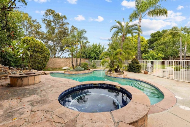 view of pool featuring a fenced backyard, a pool with connected hot tub, and a patio area