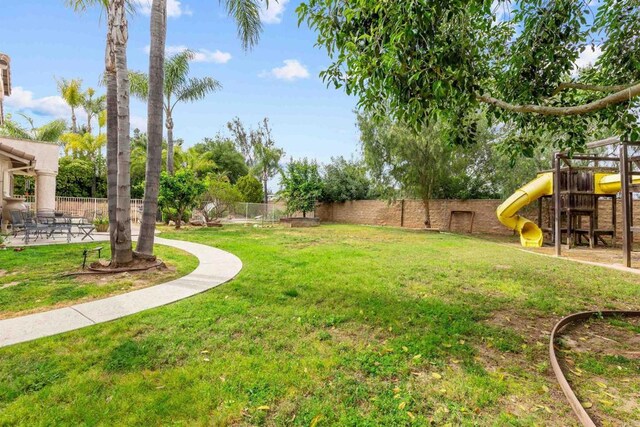 view of yard featuring a playground and a fenced backyard