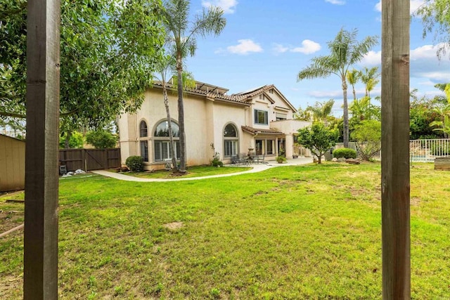 back of property featuring a patio, a fenced backyard, stucco siding, and a lawn