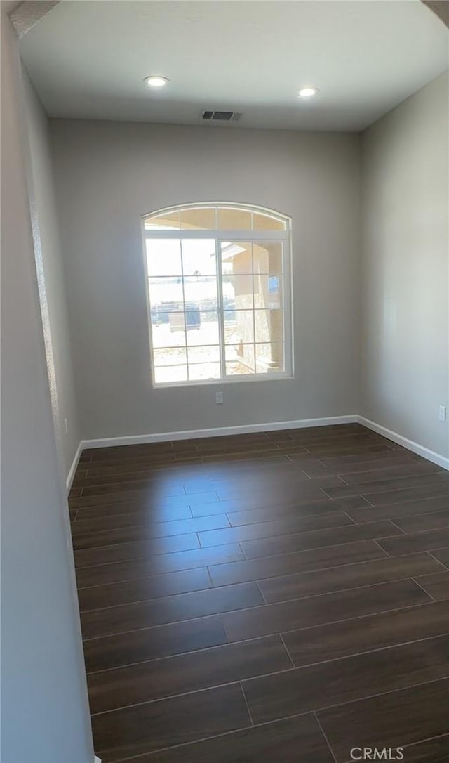 spare room with visible vents, wood finish floors, recessed lighting, and baseboards