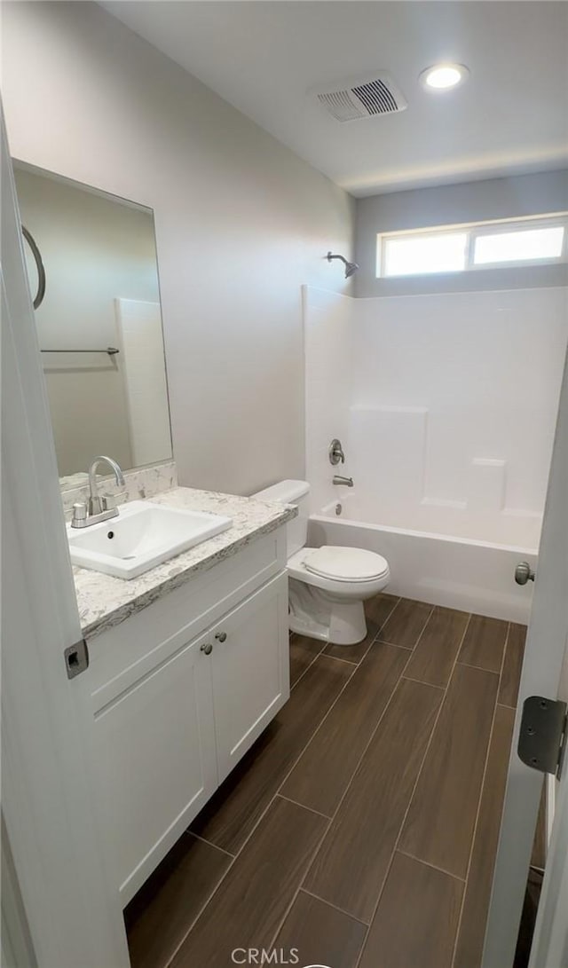 full bath with toilet, shower / bath combination, vanity, visible vents, and wood tiled floor