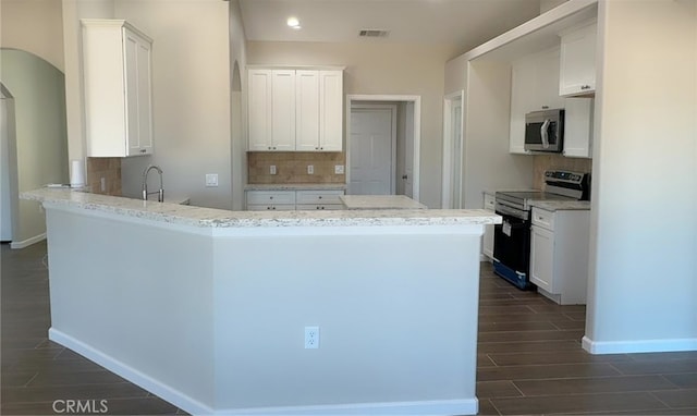 17995 Seaforth St, Hesperia, CA 92345 - kitchen with stainless steel appliances, a peninsula, wood tiled floors, arched walkways, and recessed lighting