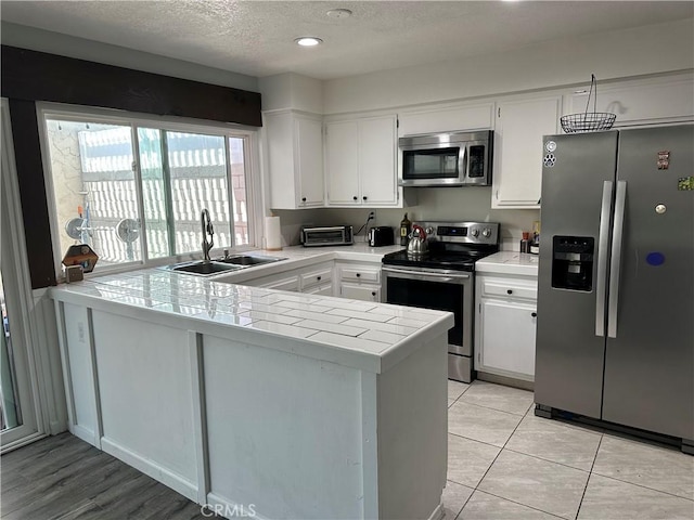 25260 Avenida Dorena, Newhall, CA 91321 - kitchen with a sink, tile counters, appliances with stainless steel finishes, and white cabinetry