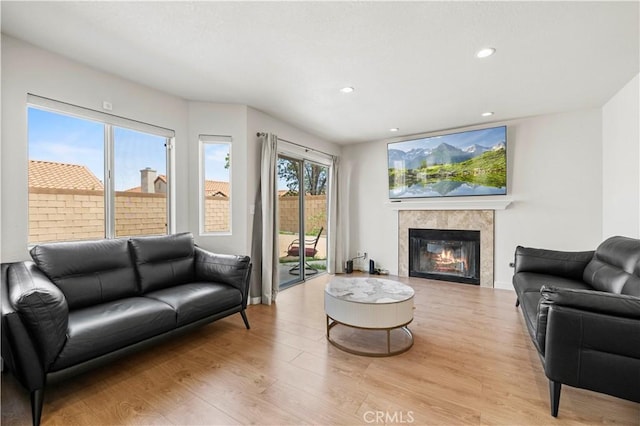 living area featuring a fireplace, recessed lighting, and light wood-style flooring