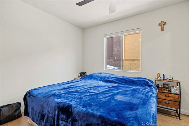 bedroom featuring baseboards, a ceiling fan, and wood finished floors