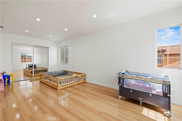 living area with recessed lighting, a wealth of natural light, and wood finished floors