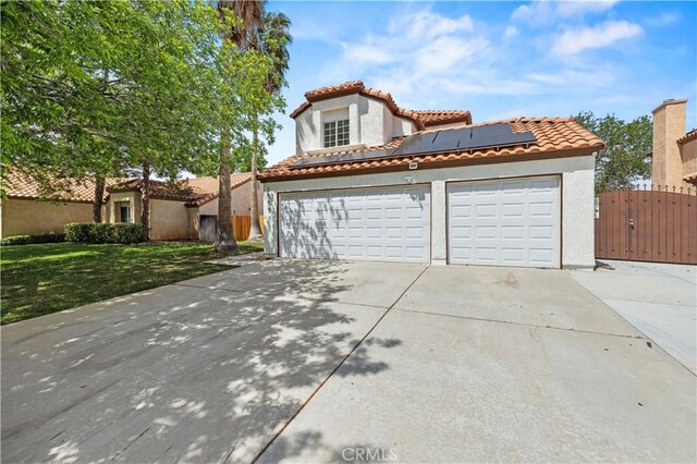 1555 Berkshire Dr, Palmdale, CA 93551 - mediterranean / spanish-style house with driveway, a gate, a garage, roof mounted solar panels, and stucco siding