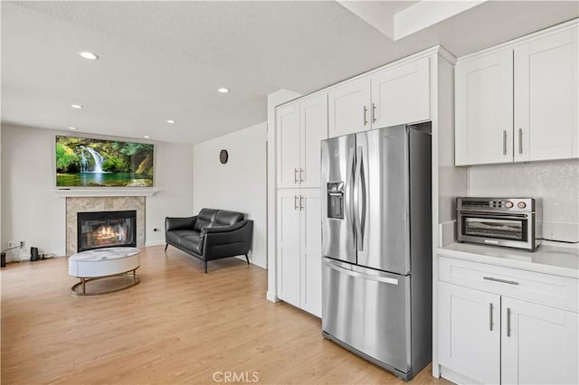 kitchen with stainless steel fridge, recessed lighting, light wood-style flooring, and white cabinetry