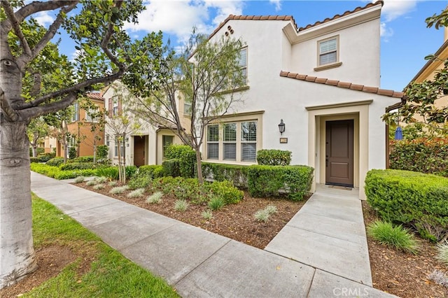 mediterranean / spanish-style home featuring stucco siding and a tile roof