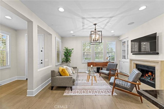 interior space featuring baseboards, a high end fireplace, wood finished floors, and recessed lighting