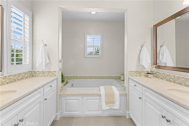 bathroom featuring two vanities, decorative backsplash, and a wealth of natural light