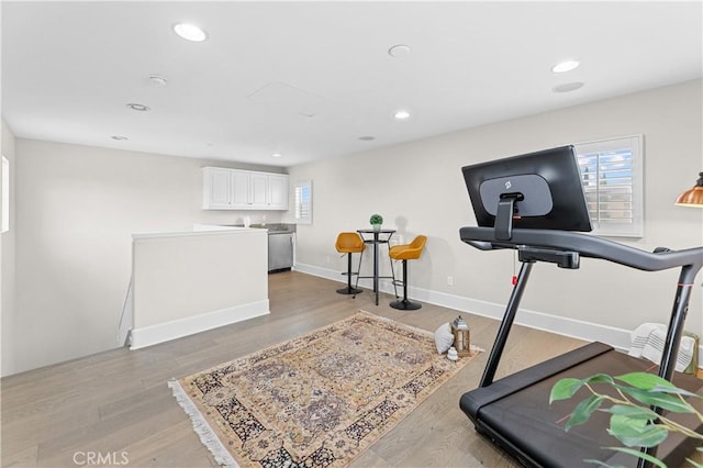 workout area featuring recessed lighting, light wood finished floors, and a healthy amount of sunlight