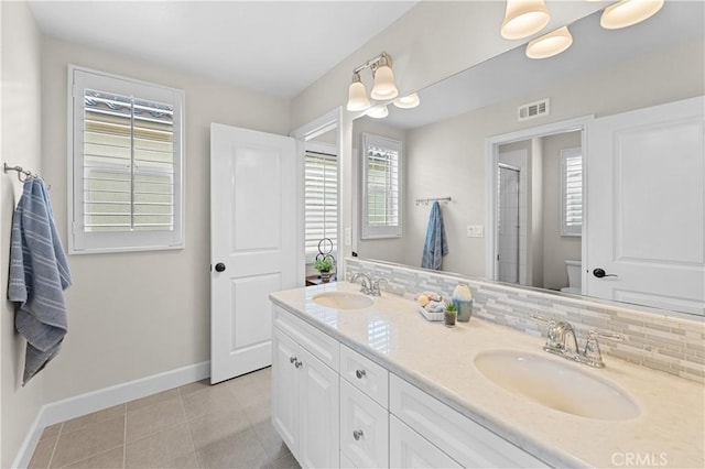 full bathroom with toilet, baseboards, visible vents, and a sink