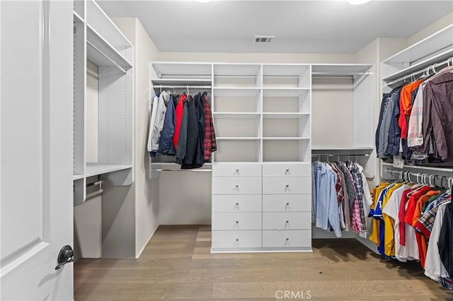 walk in closet with visible vents and wood finished floors