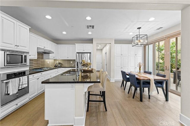 129 Pathway, Irvine, CA 92618 - kitchen with appliances with stainless steel finishes, a sink, recessed lighting, light wood-style floors, and white cabinets