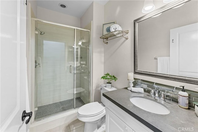 bathroom featuring backsplash, a stall shower, vanity, tile patterned floors, and toilet