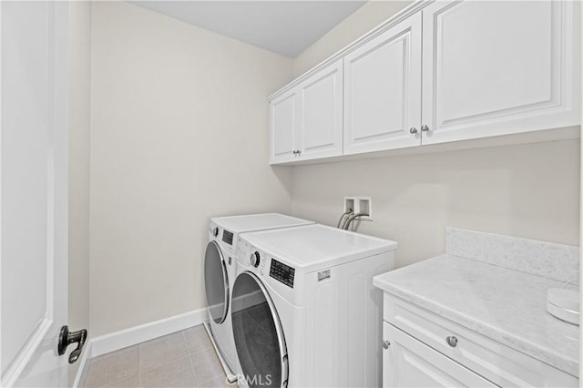 laundry room with baseboards, washing machine and dryer, cabinet space, and light tile patterned flooring