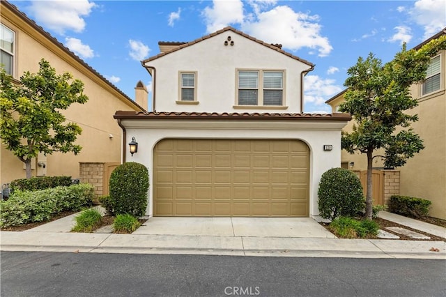 mediterranean / spanish-style house featuring a garage, stucco siding, a tile roof, and concrete driveway