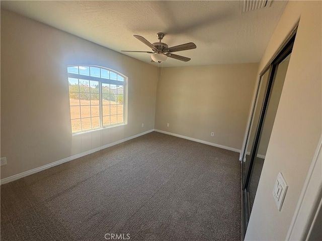 unfurnished bedroom featuring visible vents, a closet, baseboards, a textured ceiling, and carpet flooring