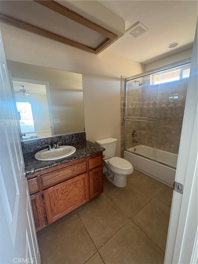 bathroom featuring vanity, toilet, tile patterned floors, combined bath / shower with glass door, and visible vents