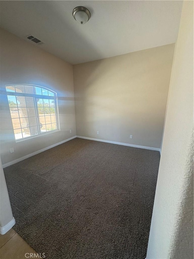 carpeted spare room featuring visible vents and baseboards