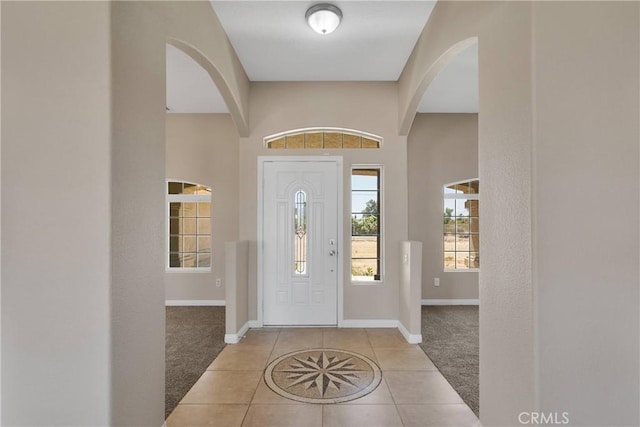 11569 Arroyo Ave, Hesperia, CA 92345 - carpeted foyer entrance featuring tile patterned flooring, arched walkways, and baseboards