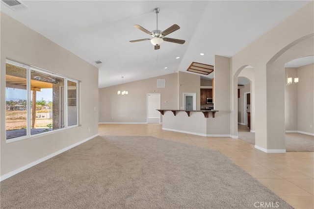 11569 Arroyo Ave, Hesperia, CA 92345 - unfurnished living room featuring light tile patterned floors, arched walkways, ceiling fan, vaulted ceiling, and a chandelier