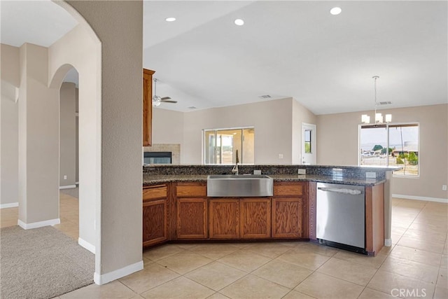 11569 Arroyo Ave, Hesperia, CA 92345 - kitchen featuring stainless steel dishwasher, a sink, brown cabinetry, arched walkways, and healthy amount of natural light