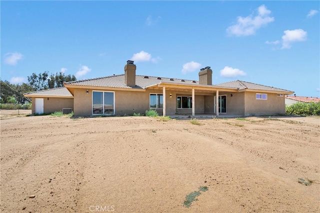 11569 Arroyo Ave, Hesperia, CA 92345 - back of house featuring a chimney, stucco siding, and a garage