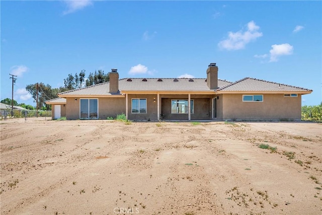 11569 Arroyo Ave, Hesperia, CA 92345 - rear view of house with a chimney, stucco siding, and a tiled roof