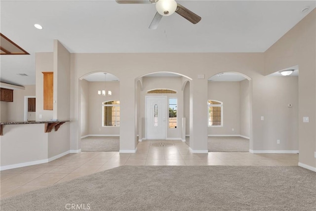 11569 Arroyo Ave, Hesperia, CA 92345 - unfurnished living room featuring light tile patterned flooring, ceiling fan, light colored carpet, and baseboards