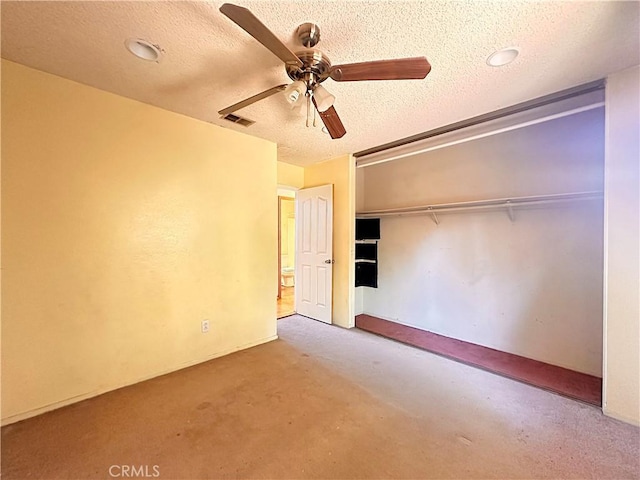 unfurnished bedroom featuring carpet flooring, a textured ceiling, a ceiling fan, visible vents, and a closet