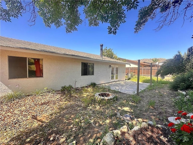 rear view of house featuring fence, a patio, and stucco siding