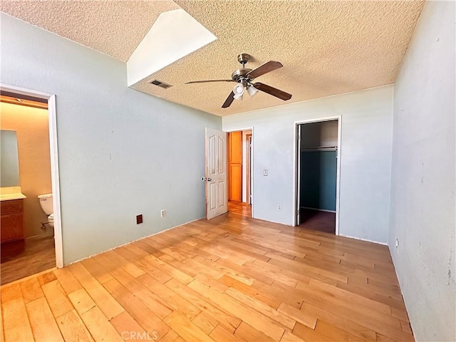 14585 Long View Dr, Fontana, CA 92337 - unfurnished bedroom with light wood finished floors, a textured ceiling, ensuite bathroom, a closet, and a spacious closet