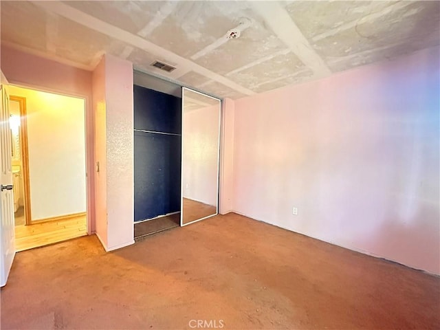 unfurnished bedroom featuring a closet and visible vents