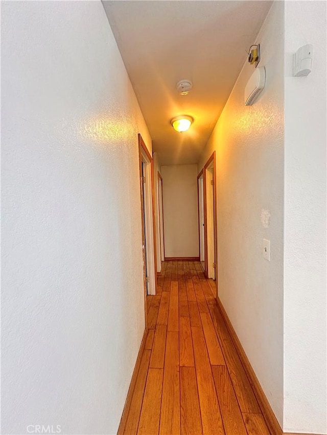 hall with baseboards and light wood-type flooring
