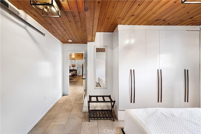 bedroom with baseboards, light tile patterned floors, refrigerator, and wooden ceiling