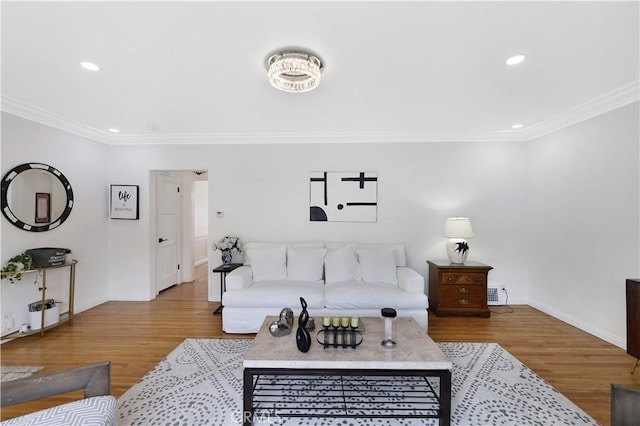 living area with baseboards, ornamental molding, and wood finished floors