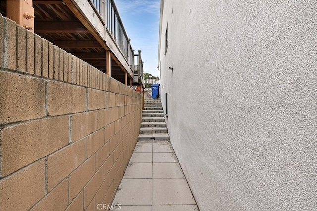 view of side of property with stairway and stucco siding