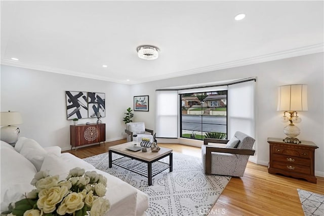 living area featuring crown molding, recessed lighting, baseboards, and light wood-style floors