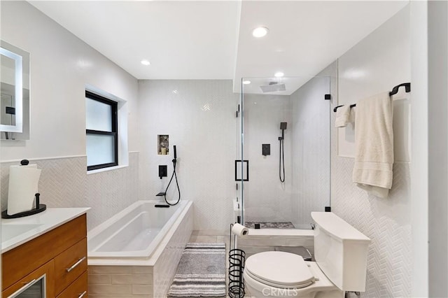 full bathroom with a garden tub, tile walls, a stall shower, vanity, and toilet