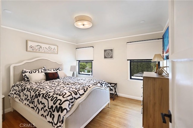 bedroom featuring baseboards, ornamental molding, and wood finished floors