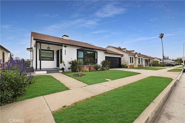 view of front of home with a garage, a front lawn, stucco siding, and concrete driveway