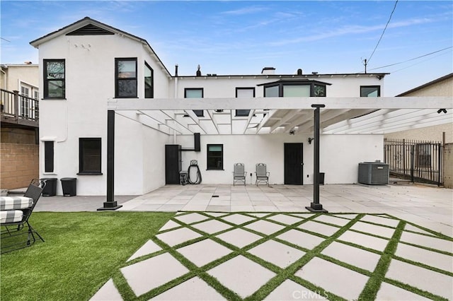 back of house with central AC, fence, stucco siding, a patio area, and a lawn