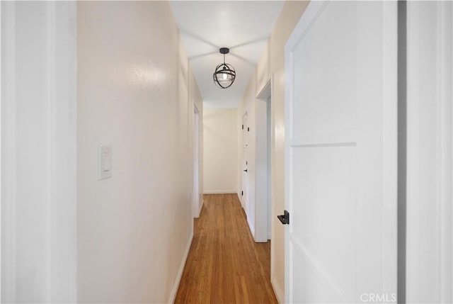 hallway featuring baseboards and light wood-type flooring