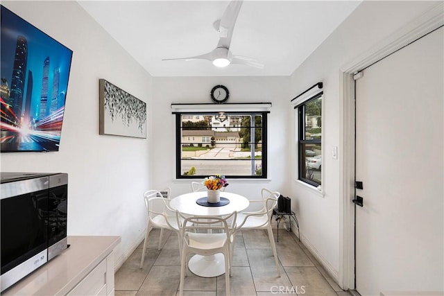 dining area with baseboards, a ceiling fan, and light tile patterned flooring