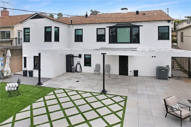 back of property featuring central air condition unit, a patio area, and stucco siding