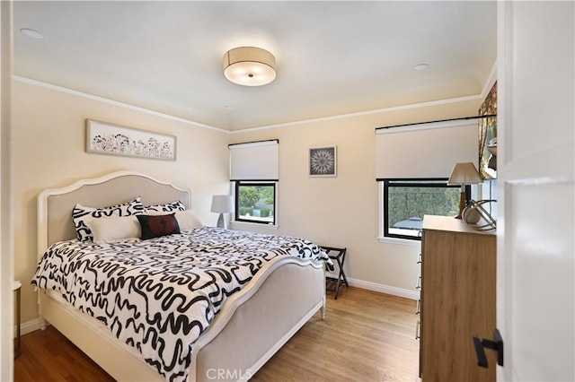 bedroom featuring baseboards, ornamental molding, and wood finished floors